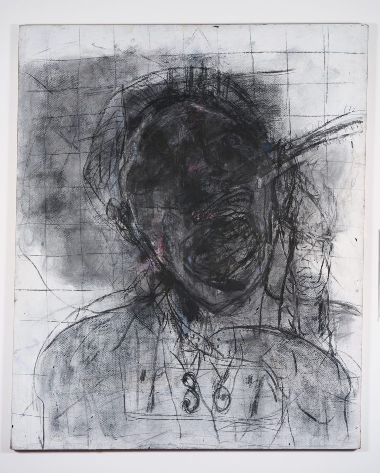 A work in charcol and oil depicting a very distorted figure from the shoulders up. The face and twisted features of the figure are obscured by dark smudging.