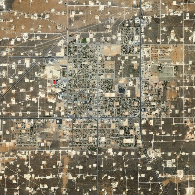 An aerial photograph showing an oil and gas facility. From this perspective it resembles a computer chip board.