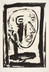 A simple monotone print, depicting a stylised self portrait of the artist. The image has a thick black boarder, and shows a round head, with prominent nose, two small eyes, and small mouth. On the cheek there is a large black, vertical smudge and the neck and torso are also depicted by only smudges.