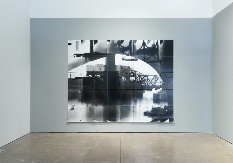 This is a black and white photo depicting some machinery on the dock outside the window.