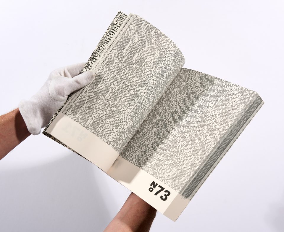 two gloved hands hold open a book, the pages of which are full of numerical code