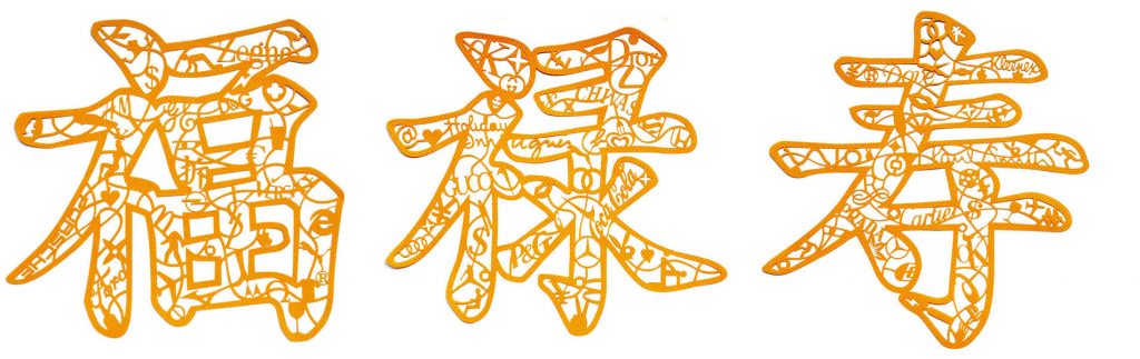 There are three orange paper-cut works on the picture, each with the Chinese characters Fu Lu Shou.