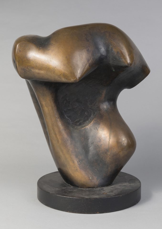 An abstract bronze sculpture on a plain gray background.