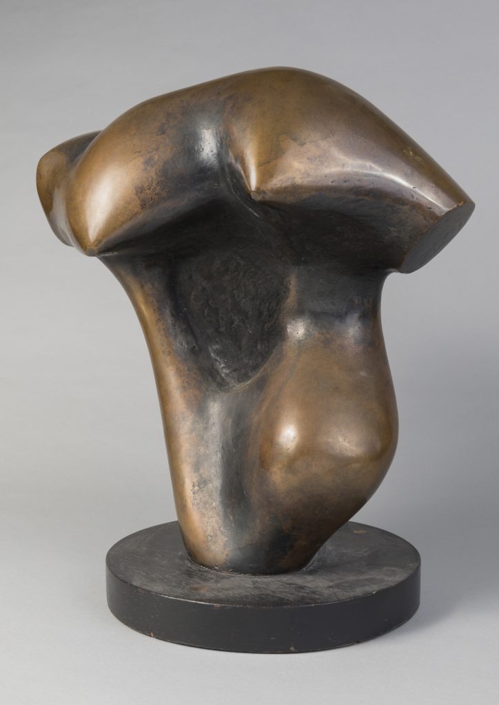 An abstract bronze sculpture on a plain gray background.