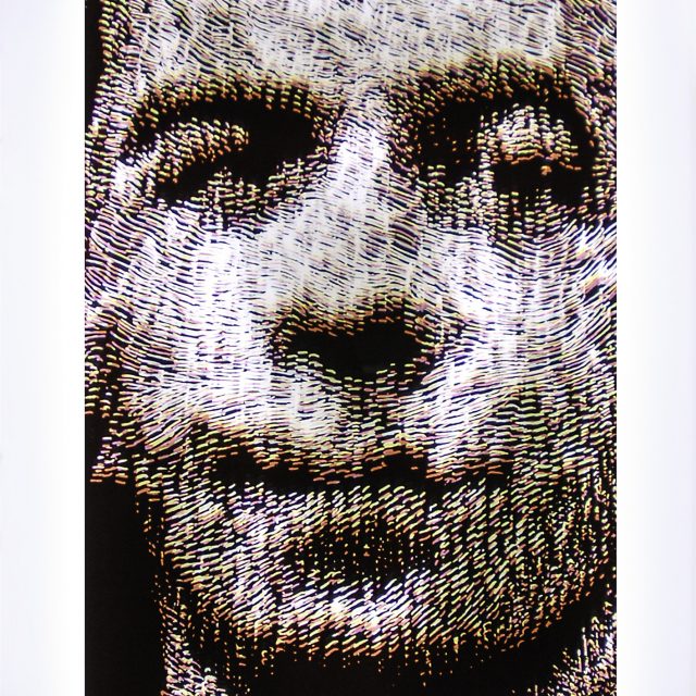 Layers of cyan, magenta, and yellow hand carved marks form the image of a mans face.