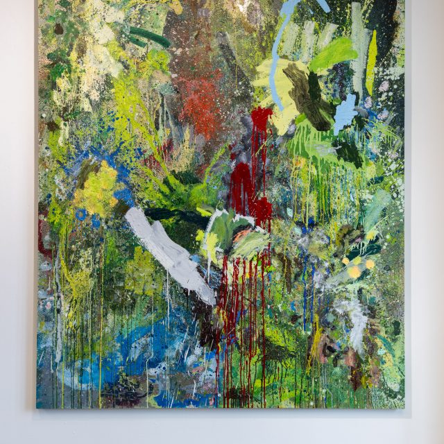 A large oil painting. spouts of crimson red, sky blue, and hints of yellow emerge through a luscious collection of forest greens.